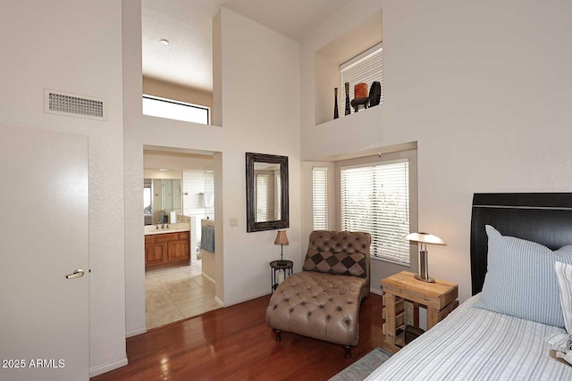 9115 N 101st Way, Scottsdale, AZ 85258 - bedroom with light wood-style floors, a towering ceiling, baseboards, and ensuite bathroom