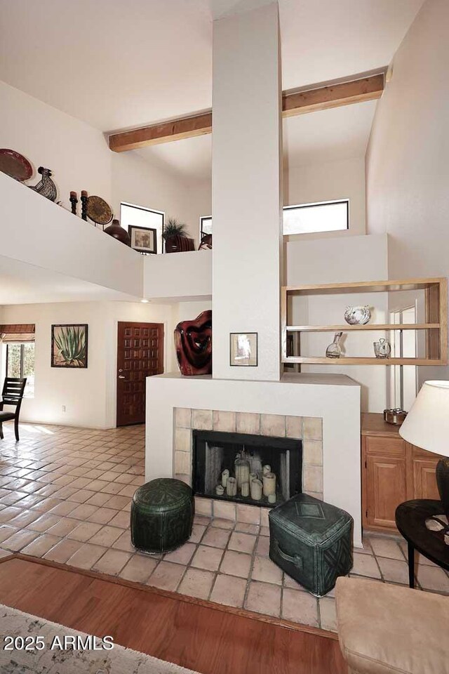 9115 N 101st Way, Scottsdale, AZ 85258 - living room featuring plenty of natural light, beamed ceiling, a towering ceiling, a tile fireplace, and tile patterned floors