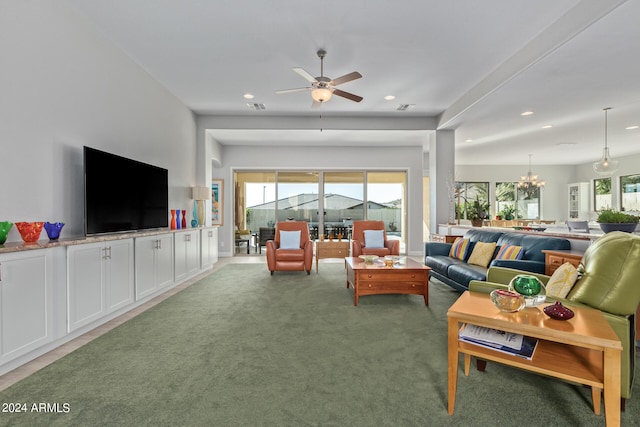 living room with carpet floors and ceiling fan with notable chandelier