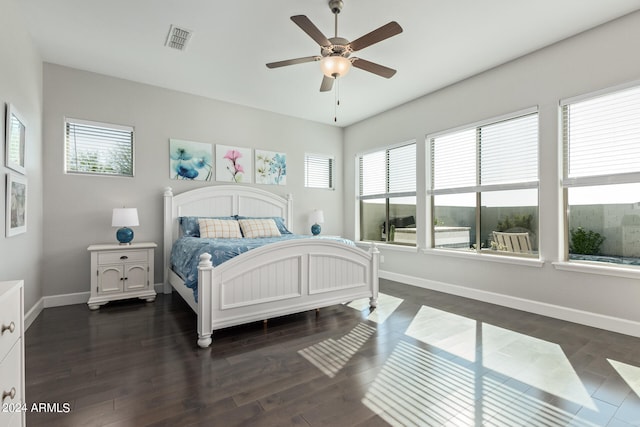 bedroom featuring ceiling fan, dark wood-type flooring, and multiple windows