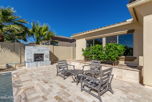 view of patio with exterior fireplace