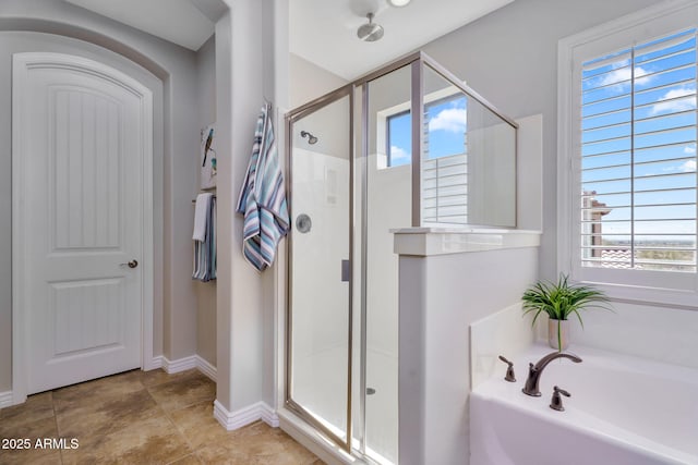 full bath featuring tile patterned floors, a bath, baseboards, and a stall shower