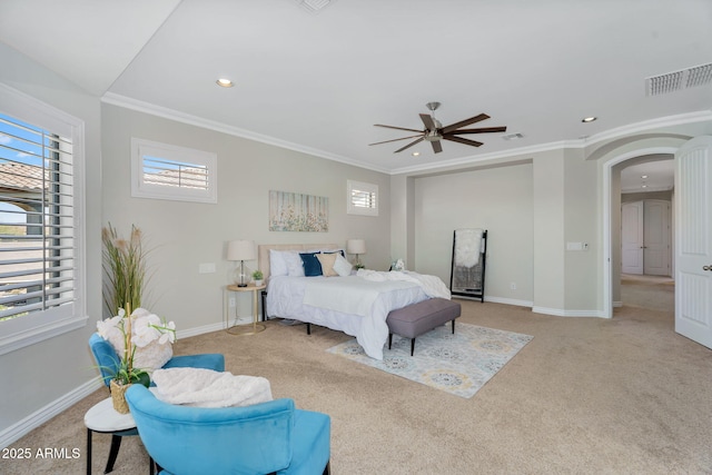 carpeted bedroom with visible vents, crown molding, baseboards, recessed lighting, and arched walkways