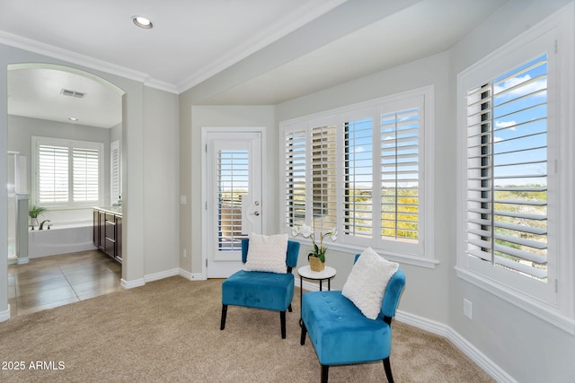 sitting room featuring ornamental molding, baseboards, visible vents, and light carpet