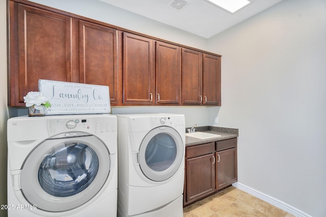 laundry room featuring visible vents, a sink, cabinet space, baseboards, and washing machine and clothes dryer