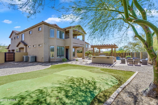 rear view of house with stucco siding, a patio, a fenced backyard, and a hot tub