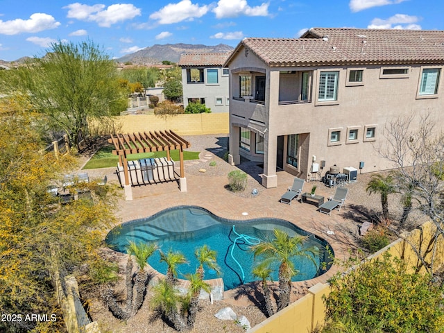outdoor pool with a mountain view, a fenced backyard, a pergola, and a patio area
