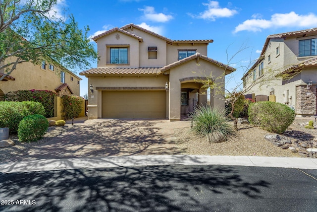 mediterranean / spanish home with stucco siding, an attached garage, driveway, and a tile roof
