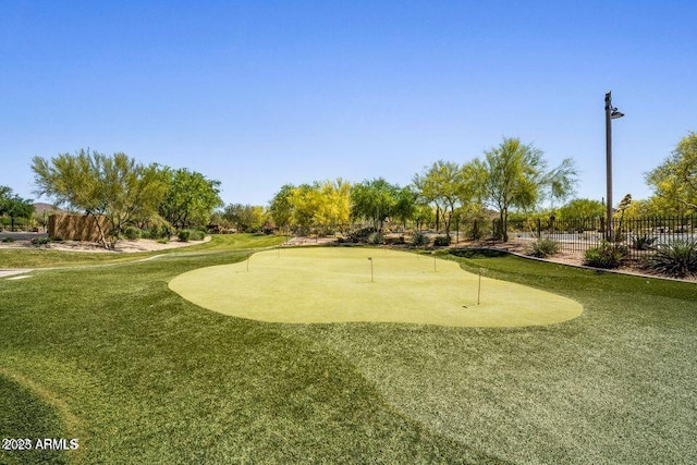 surrounding community with golf course view and fence