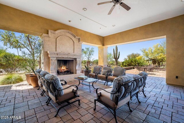 view of patio featuring ceiling fan and an outdoor living space with a fireplace
