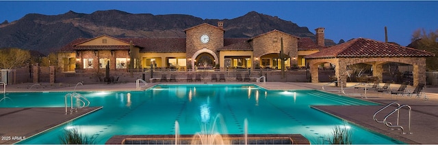 community pool featuring a gazebo, a mountain view, fence, and a patio area