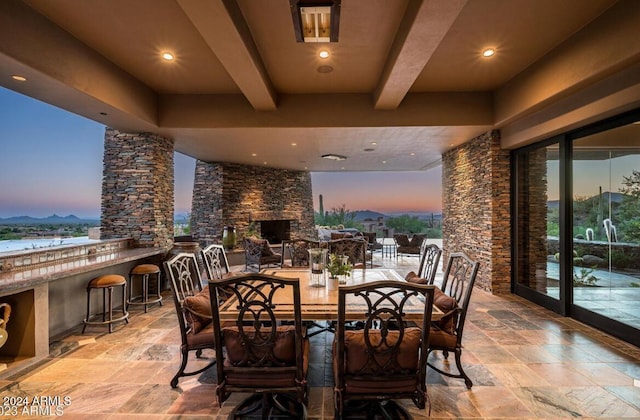 patio terrace at dusk featuring a bar