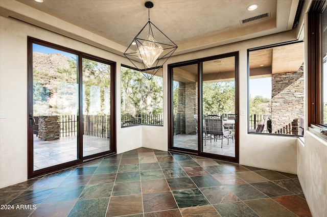 doorway featuring a healthy amount of sunlight and an inviting chandelier