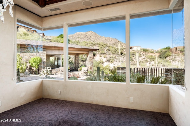 unfurnished sunroom featuring a mountain view