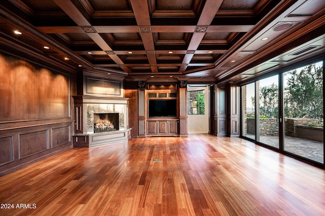 unfurnished living room with coffered ceiling, light hardwood / wood-style floors, and beamed ceiling