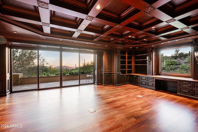 interior space with built in desk, light hardwood / wood-style flooring, a wealth of natural light, and coffered ceiling