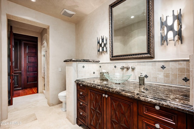 bathroom with tile patterned floors, vanity, toilet, and backsplash