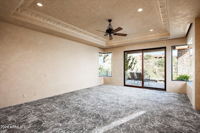 empty room with a tray ceiling, ceiling fan, and crown molding