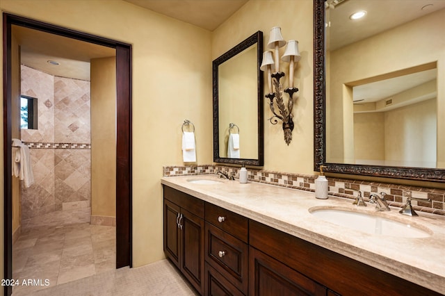 bathroom featuring tiled shower, vanity, and backsplash