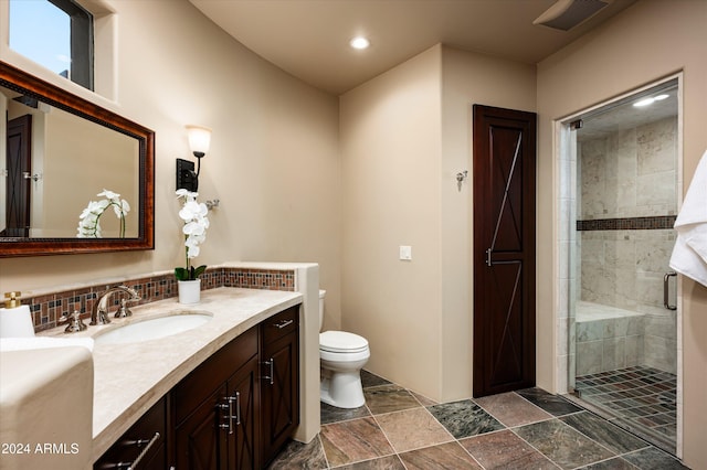 bathroom featuring an enclosed shower, vanity, and toilet