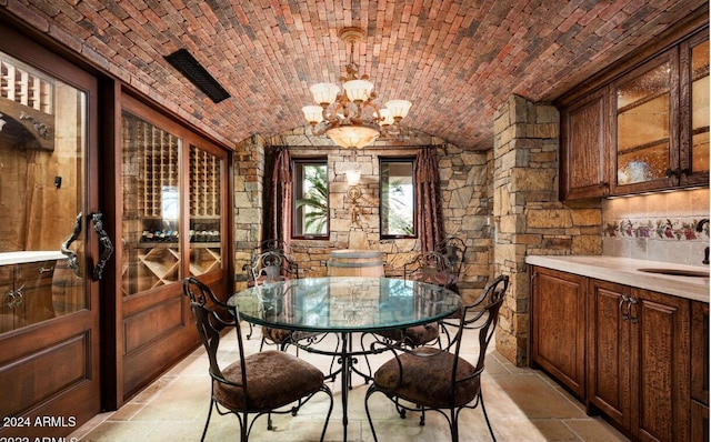 dining room with a chandelier, brick ceiling, lofted ceiling, and sink