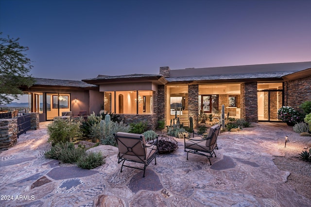 back house at dusk with a patio