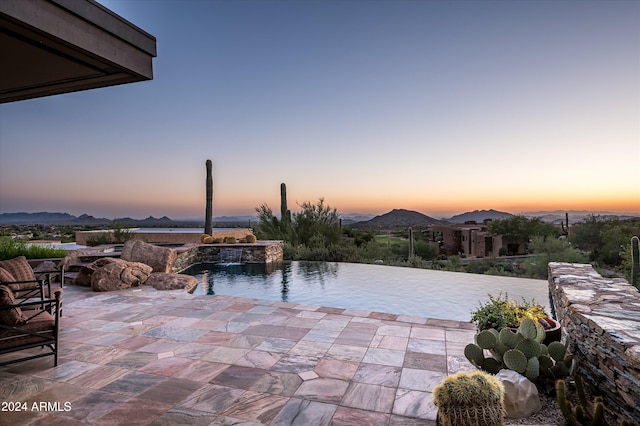 exterior space featuring a mountain view and an in ground hot tub