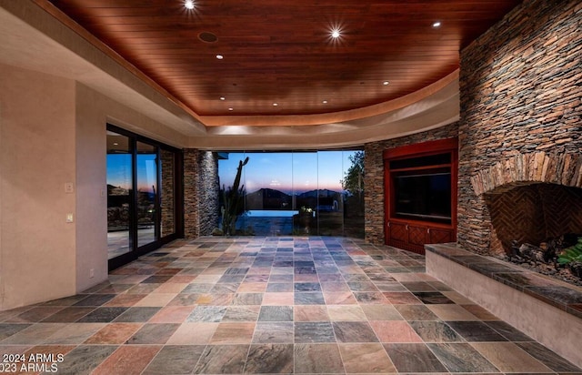 hallway with a tray ceiling and wooden ceiling