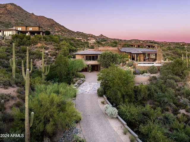 aerial view at dusk featuring a mountain view