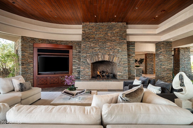 living room featuring wooden ceiling and an outdoor stone fireplace