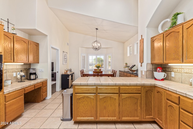 kitchen with tile countertops, pendant lighting, kitchen peninsula, and light tile patterned flooring