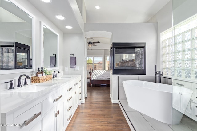 bathroom featuring a washtub, vanity, wood-type flooring, and ceiling fan