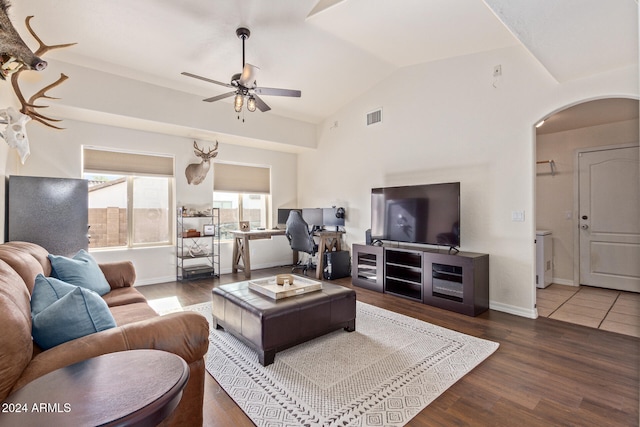 living room featuring dark wood-type flooring, ceiling fan, and vaulted ceiling