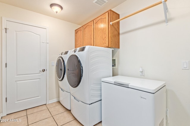 laundry area with cabinets, washer and dryer, and light tile patterned flooring