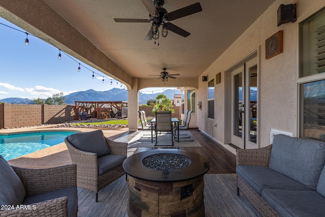 view of patio with french doors, a pool side deck with mountain view, outdoor lounge area, and ceiling fan