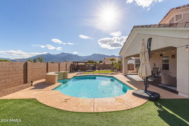 view of swimming pool with a patio and a mountain view