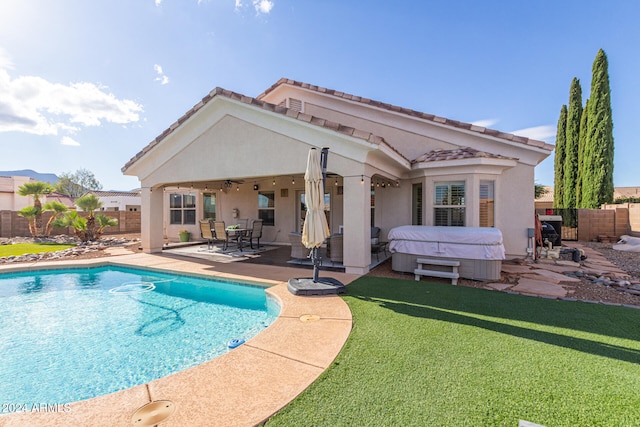 view of pool with a hot tub, a patio area, a yard, and ceiling fan