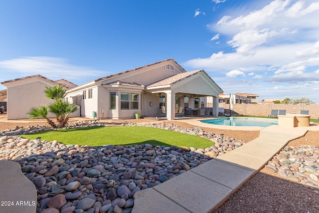 back of property with a fenced in pool and a patio area