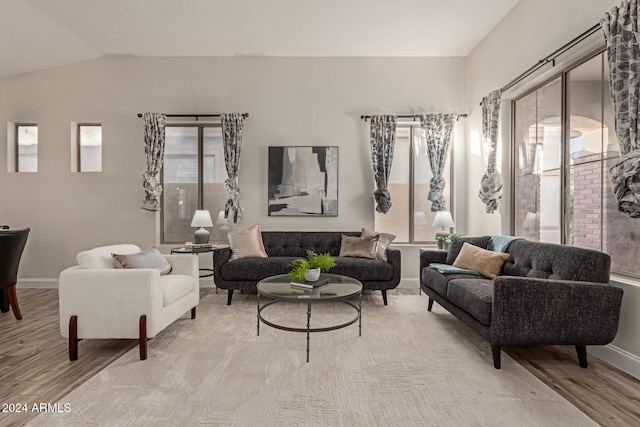 living room with light hardwood / wood-style floors and lofted ceiling