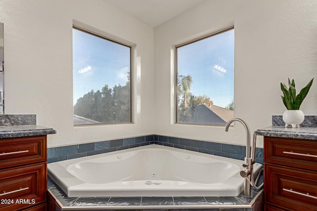 bathroom featuring vanity and tiled tub