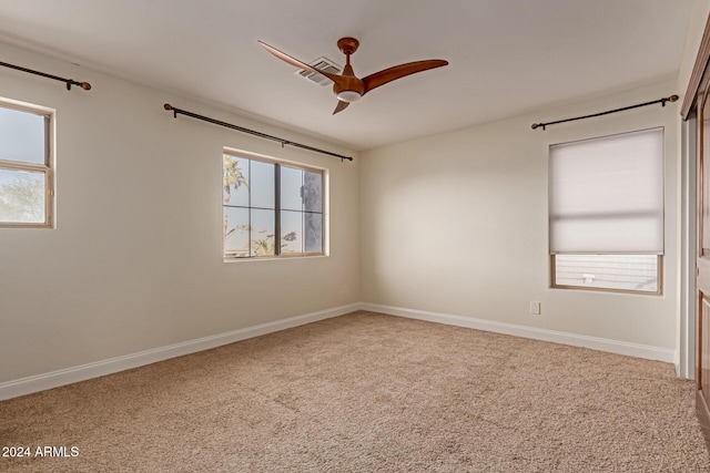 carpeted spare room with ceiling fan