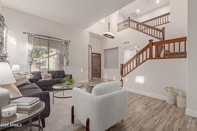 living room with a high ceiling and light hardwood / wood-style floors