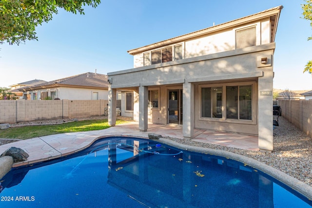 back of house featuring a fenced in pool and a patio area