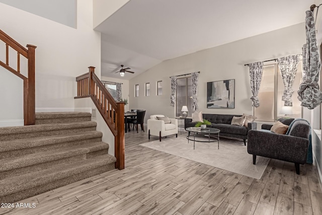 living room featuring ceiling fan, light hardwood / wood-style floors, and lofted ceiling