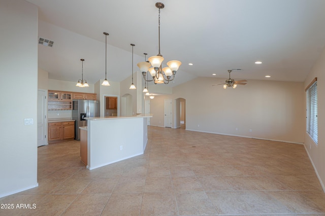 kitchen with hanging light fixtures, stainless steel fridge with ice dispenser, high vaulted ceiling, a kitchen island, and ceiling fan with notable chandelier