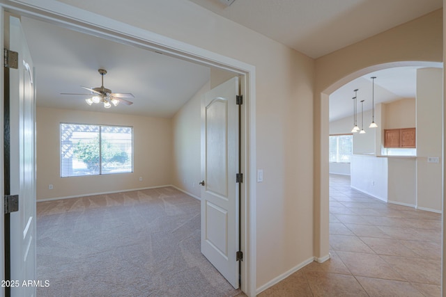 tiled spare room featuring ceiling fan, a healthy amount of sunlight, and vaulted ceiling