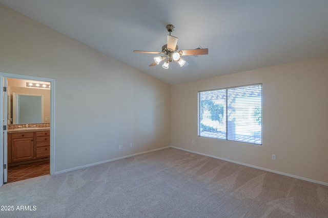 empty room featuring ceiling fan, lofted ceiling, and light carpet