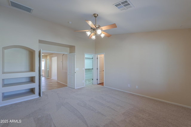 unfurnished bedroom featuring ceiling fan, light carpet, connected bathroom, and vaulted ceiling