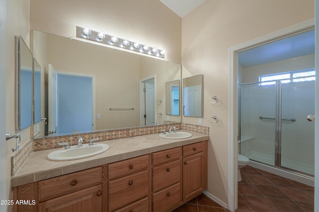 bathroom with tasteful backsplash, tile patterned floors, toilet, vanity, and a shower with shower door