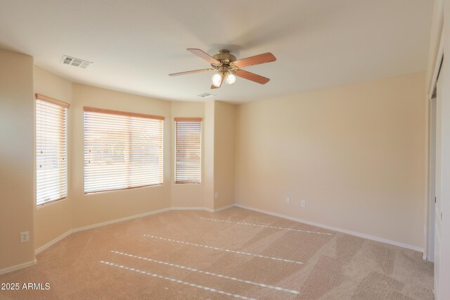 carpeted spare room with ceiling fan